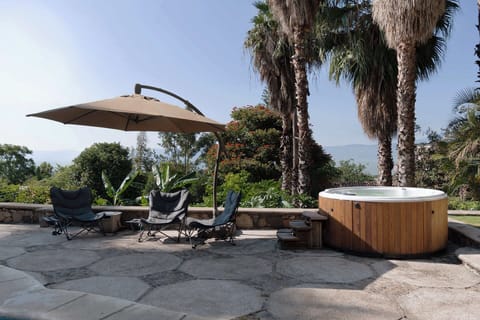 Jacuzzi | Soak in the outdoor whirlpool with stunning lake and hillside views