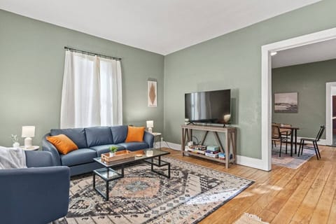 Stream your favorite shows on the smart TV in this open-concept Fort Wayne living room, arranged with a geometric rug and plenty of seating for group movie nights.