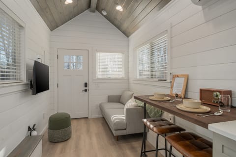 Main floor living area at Frost — Smart TV with streaming capabilities, clean lines, warm wood tones throughout