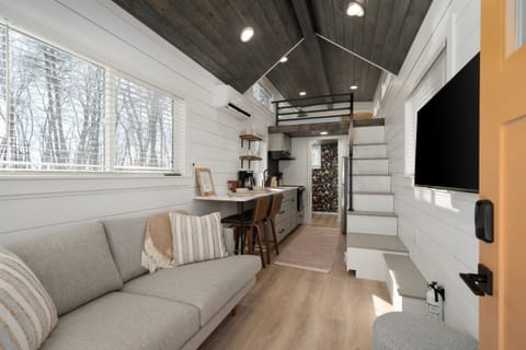 Main floor living area at Yeats — Smart TV with streaming capabilities, sofa, staircase to the lofted queen bed above