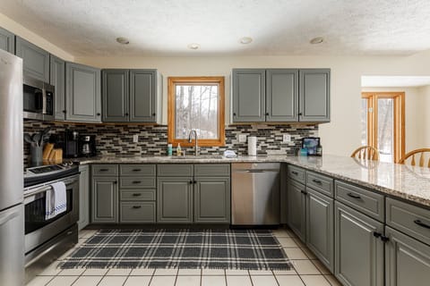 Modern kitchen w/ sleek gray cabinetry, stainless appliances & generous counter space for easy meal prep.