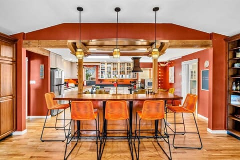 Stylish Kitchen Bar & Gathering Space - This spacious kitchen bar offers seating for six, perfect for casual meals or entertaining. Warm wood beams, elegant lighting, and an open layout create a welcoming atmosphere for friends and family.