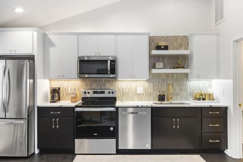 Fully equipped kitchen with all your cooking essentials, drip coffee maker + coffee. Dining table with seating for 2. This room opens up into the living room. Chic colors, neon lights and decor all throughout the condo.