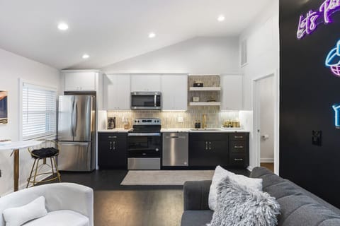 Fully equipped kitchen with all your cooking essentials, drip coffee maker + coffee. Dining table with seating for 2. This room opens up into the living room. Chic colors, neon lights and decor all throughout the condo.