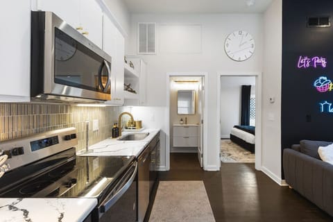 Fully equipped kitchen with all your cooking essentials, drip coffee maker + coffee. Dining table with seating for 2. This room opens up into the living room. Chic colors, neon lights and decor all throughout the condo.