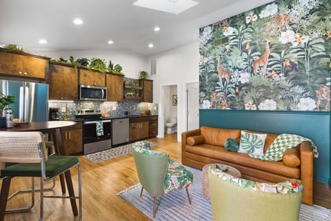 Comfortable living room with lots of natural light! Smart TV with all the apps you could want. The couch turns into a futon sofa. Lush, vibrant decor throughout the entire condo!