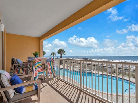Step onto your private balcony and soak in stunning beach views while lounging in comfort with colorful towels and cozy seating.