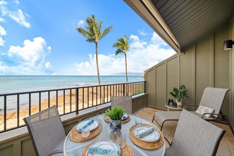 Stunning oceanfront lanai with a four‑seat dining set, perfect for enjoying meals with panoramic views of the turquoise Maui shoreline.