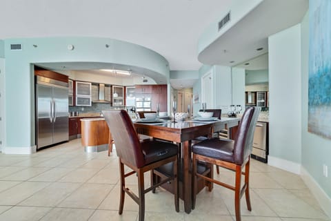 A stylish dining set takes center stage in this well-appointed dining area. The open kitchen and comfortable seating provide an ideal setting for casual meals or formal dinners.