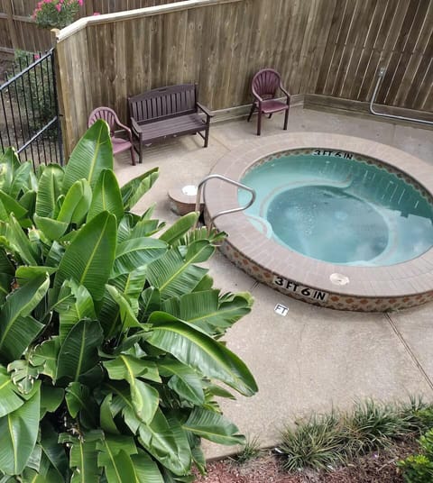 Private outdoor hot tub with tropical greenery and cozy patio seating
