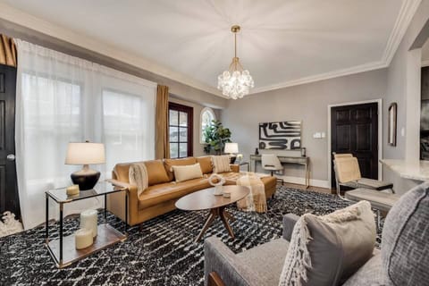 Enjoy counter seating in a spacious, bright living room with leather chaise that seamlessly flows into the open-plan kitchen, creating an inviting and airy atmosphere.