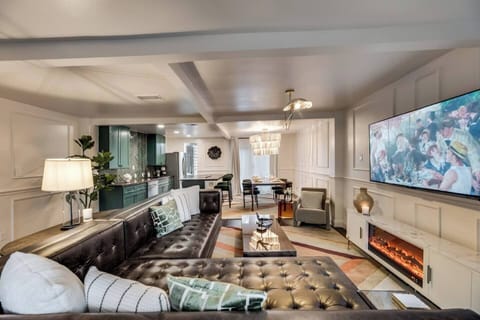 Spacious living room with a roomy leather sectional and plenty of seating, plus a 65" Smart TV for ultimate relaxation and entertainment.