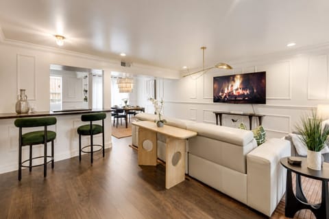 Open floor plan with seamless access to the dining area, kitchen, and living room, featuring a large 65" smart TV.