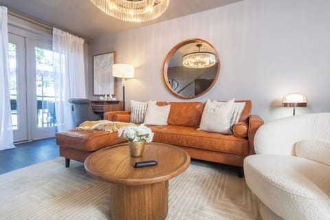 French doors open to the outdoor patio, living room with a roomy leather sectional and plenty of seating, plus a large Smart TV for ultimate relaxation and entertainment. 