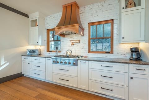 Gourmet kitchen dishwasher, gas range, and drip-style coffee maker.