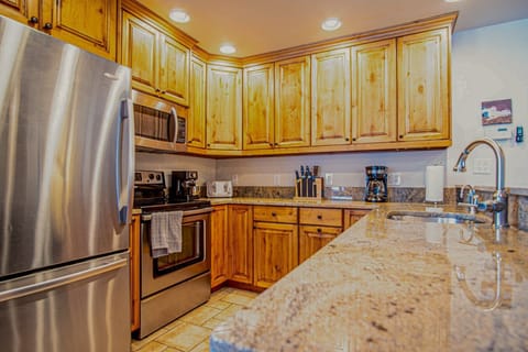 Newly updated kitchen with custom cabinets, granite countertops, and seating for three at the bar