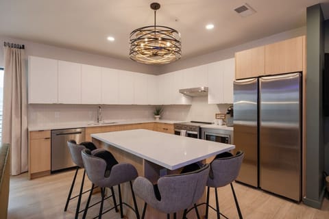 Open-concept kitchen with modern appliances, stylish lighting fixture, and a cozy seating area perfect for entertaining.