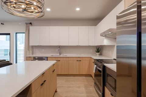 Stylish and functional kitchen with sleek white cabinetry, stainless steel appliances, and natural wood accents.