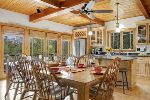 Enjoy family meals or game nights at this bright dining table with forest views.