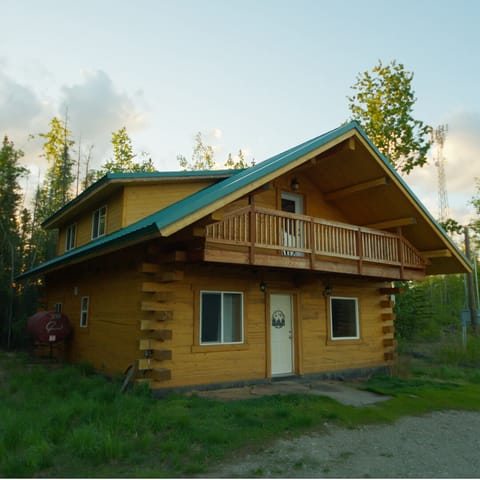 Rustic forest cabin with covered balcony and peaceful wooded setting