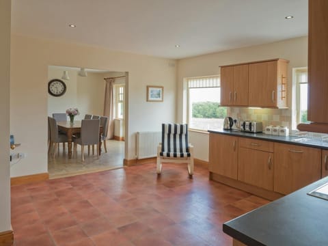 Kitchen, stripey chair, clock on the wall in the dining room