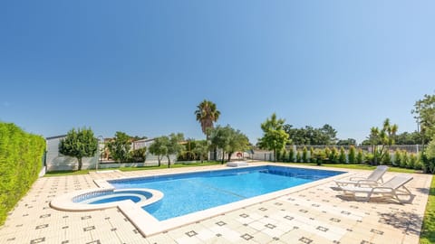 Dive into summer fun or lounge by the expansive pool, surrounded by lush greenery and clear blue skies. #PoolsideParadise #OutdoorBliss