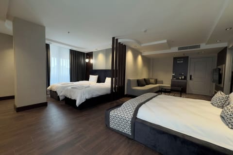 Deluxe Quadruple Room, City View | Hypo-allergenic bedding, free minibar, in-room safe, desk