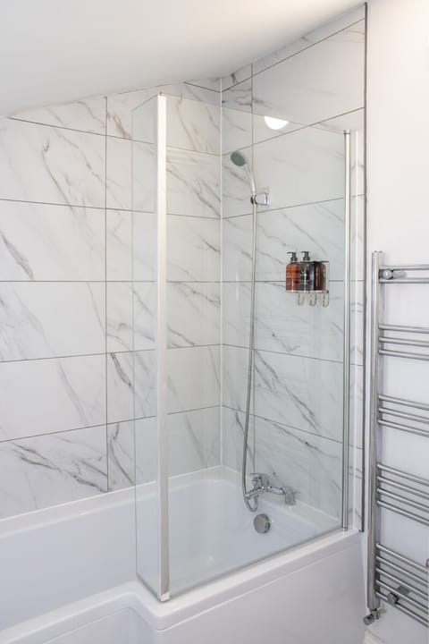 Contemporary bathroom with stylish bath and shower, perfect for relaxing after a long day.