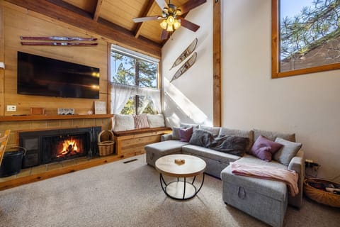 Great living room space with cozy seating area, flatscreen TV, and wood stove.
