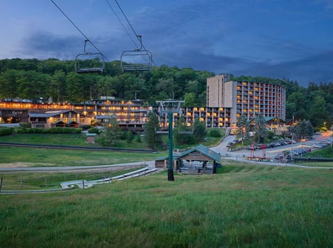 Scenic view of the property at dusk, with ski lifts and cozy accommodations illuminated against a peaceful mountain backdrop.