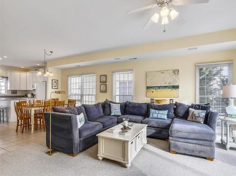 Open-concept living room with plush seating, large windows, and smart TV for ultimate comfort.