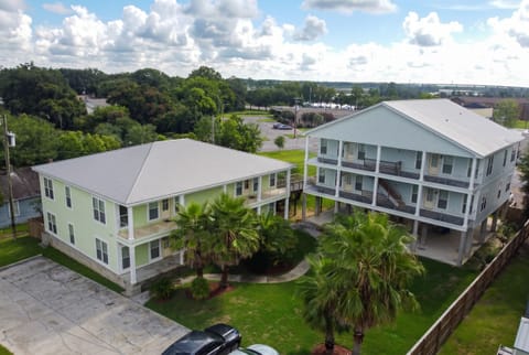 Spacious elevated homes with balconies, palm trees, and tropical courtyard