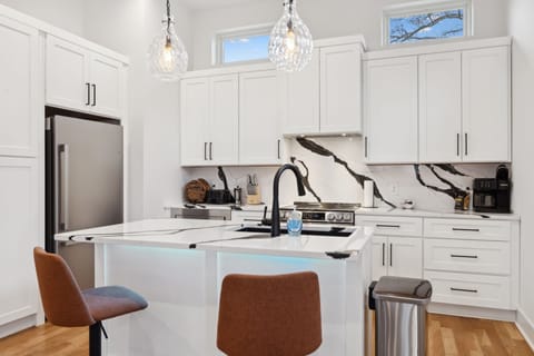 Kitchen: The open kitchen offers a bright, welcoming space with modern finishes, ample counter space, and chic bar stools for a casual dining experience.