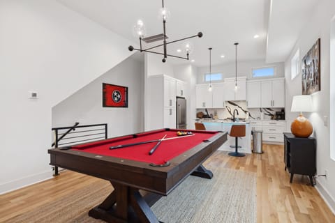 Living Room: This inviting space includes a red pool table, large sectional, and modern design elements for the perfect mix of fun and comfort.
