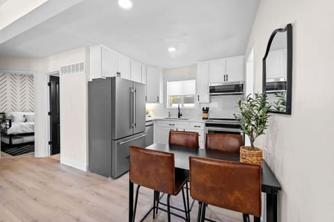 This stylish dining room seamlessly integrated with the modern kitchen, featuring custom quartz countertops, new appliances, and beautiful cabinetry. This light-filled space is perfect for family meals and entertaining in comfort and elegance.