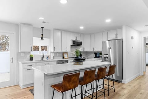 Fabulous, remodeled open-concept living room and kitchen new appliances stunning quartz countertops, and a chic backsplash! ✨ The kitchen leads to a private outdoor dining patio with a hot tub—perfect for cooking, entertaining, and relaxing! 🏡🍽️🛁