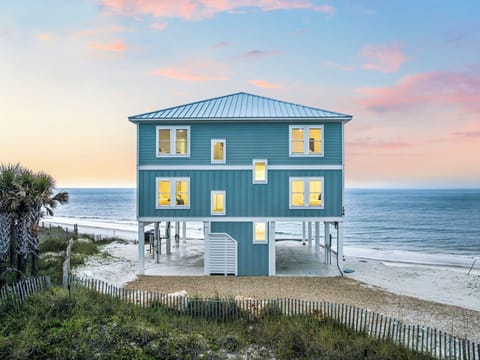 Stunning beachfront property with direct ocean access and breathtaking coastal views. This elevated blue beach house sits right on the shoreline, offering an idyllic seaside retreat.