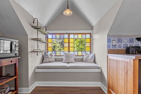 The 3rd floor spacious upstairs apartment has a full living area, TV, kitchenette and sitting space- and beautiful stain-glass windows in a reading nook