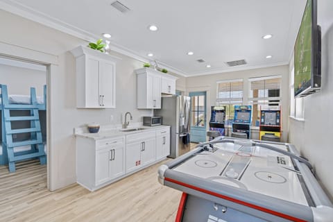 3rd Floor - Game room with 3 custom arcade machines, an air hockey table, and a 4K Smart TV, plus a kitchenette with full fridge/freezer, sink, and microwave—perfect for family game nights and entertaining during your Miramar Beach vacation!
