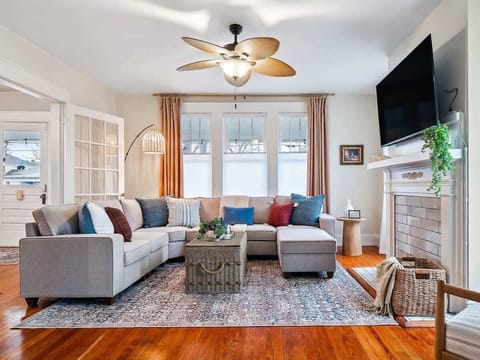 Spacious living room w/ soft tones, comfy seating & natural light throughout