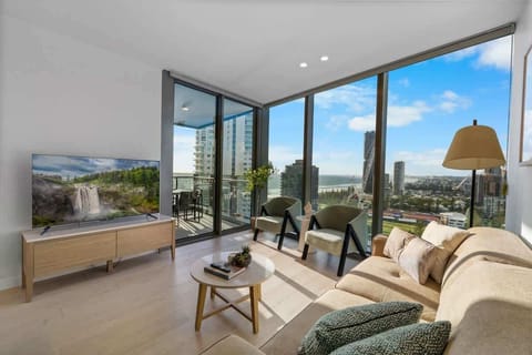 Spacious living room with a high ceiling, floor-to-ceiling windows, and an amazing Southeastern coastline and Ocean view.