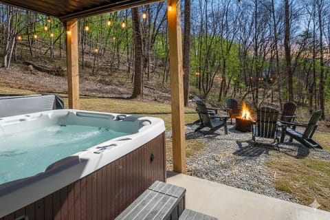 Private hot tub at Hemingway — tucked under the covered lower deck, Adirondack seating and fire pit just steps away