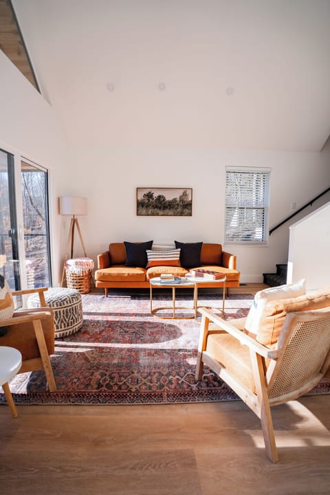 Main floor living area at Hemingway — open concept, large windows, leather sofa, natural light throughout