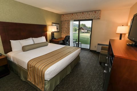 Cozy room with a comfortable bed, TV, and private balcony access for a relaxing stay.