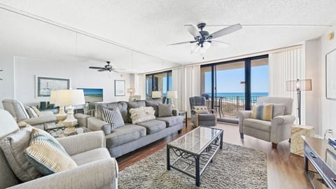 Step into this bright living room with floor-to-ceiling Gulf views, plush seating, and a balcony for ocean breezes and relaxation.