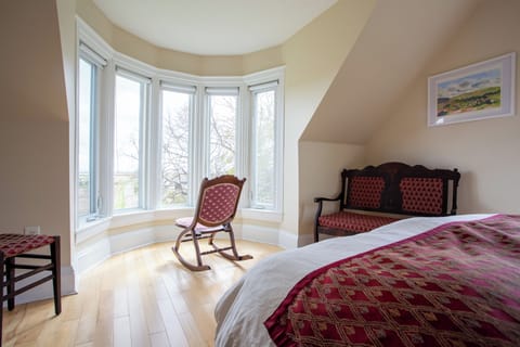 Queen bed room with big bay windows towards the Bay of Fundy.