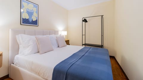 Unwind in this comfortable bedroom featuring a plush double bed, perfect for a restful night's sleep after a day of exploring. A stylish open wardrobe provides ample space for your belongings, keeping the room tidy and chic.