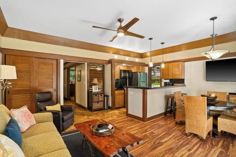 Settle into your open concept living space where warm wood tones and tropical touches create your island retreat. The fully equipped kitchen and cozy dining area await your favorite meals.