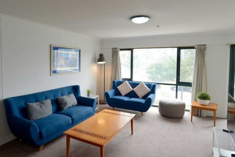 The lounge room offers a cozy and inviting atmosphere, featuring plush blue sofas that provide a perfect spot to relax and unwind. The combination of comfort and style creates a welcoming space for guests to enjoy.