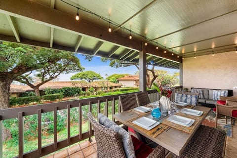 Covered lanai with cushioned seating and tropical garden views, ideal for relaxing outdoors in a serene Maui setting.